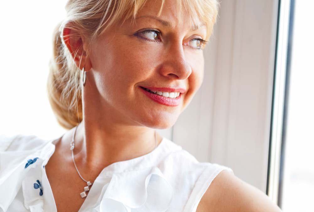 Older woman looking out window and smiling